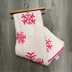 two white and pink snowflakes are hanging on a wooden hanger