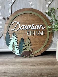 a wooden sign that says davidson with trees and a bear