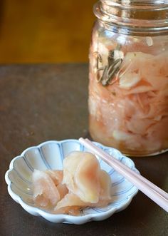 some food is in a bowl on a table next to a jar with chopsticks