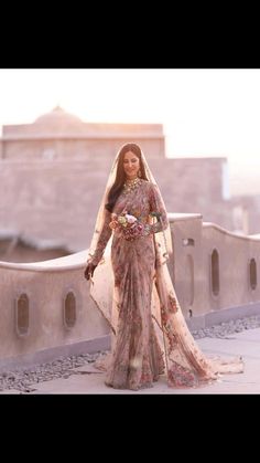 a woman in a wedding dress standing on a balcony