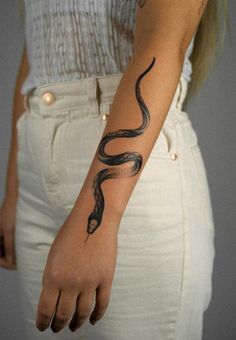 a woman with a snake tattoo on her arm