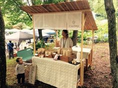 a man and child standing in front of a table with food on it at an outdoor market