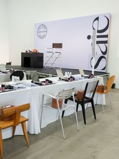 several chairs and tables are set up in front of a large sign with the word design on it