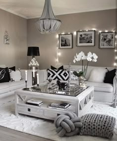 a living room filled with white furniture and lots of lights