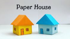 two paper houses sitting next to each other on top of a white surface with the words paper house