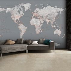 a living room with a gray couch and a large map on the wall behind it