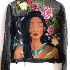 a denim jacket with an image of a woman's face painted on the back