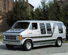 the van is parked in front of some trees