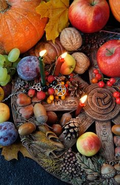 an assortment of fruits and vegetables on a plate with candles in the shape of a cross