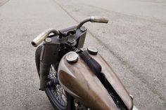 an old motorcycle is parked on the side of the road with no one around it