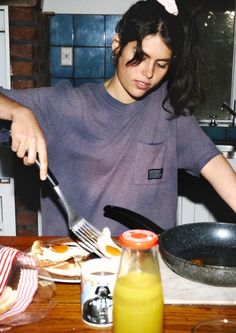 a man is cutting into some food with a knife and fork on the table in front of him