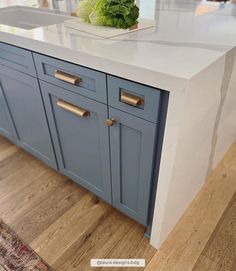 a kitchen with blue cabinets and white counter tops