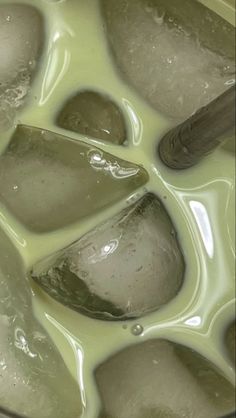 ice cubes are melting in a pot of green liquid