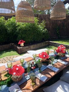 the table is set with red umbrellas and place settings for an outdoor dinner party