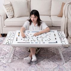 a woman sitting at a coffee table with a board game on it's legs