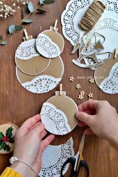 someone is making some paper doily ornaments with scissors and twine on the table