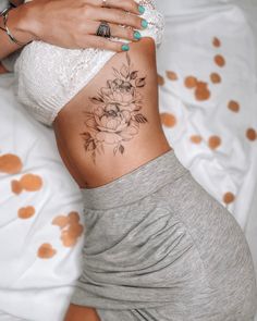 a woman with a flower tattoo on her stomach