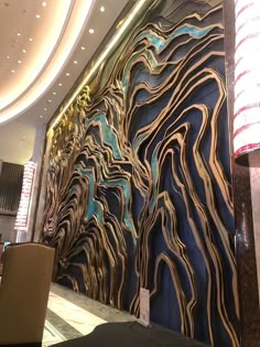 an artisticly designed wall in the lobby of a hotel or restaurant with chairs and tables