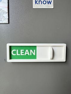 a white and green clean sign on a gray refrigerator