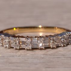 a diamond ring on a wooden surface, with the middle band partially covered in diamonds