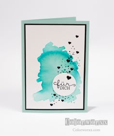 a card with watercolor paint on it and the words, love is in the air