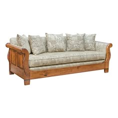 a wooden couch with many pillows on it's back and arm rests against a white background