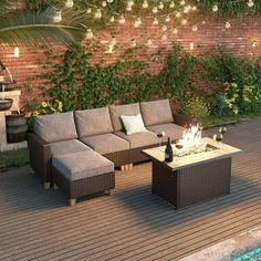 a couch and table sitting on top of a wooden deck next to a swimming pool