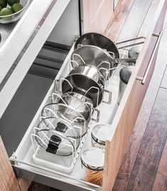 an open drawer with pots and pans in it