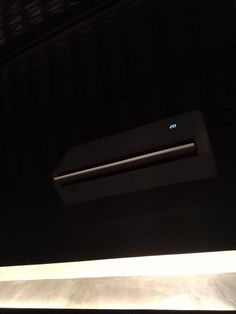 an air conditioner sitting on top of a counter in a room with black walls