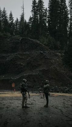 two soldiers standing in the middle of a forest