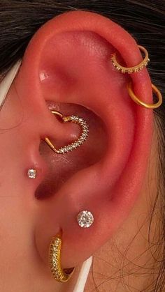 a woman wearing three different types of ear piercings on her left side of the ear