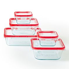 four glass containers with red lids on white background