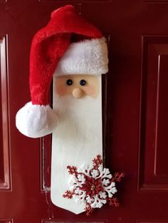 a door hanger with a santa clause hat and snowflakes attached to it