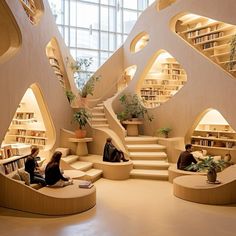 two people are sitting in the middle of a room with bookshelves and stairs