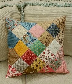 a patchwork pillow sitting on top of a couch