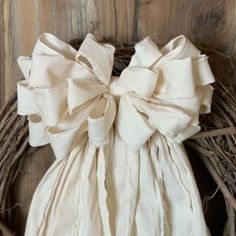 a white bag sitting on top of a wooden table next to a wreath filled with branches