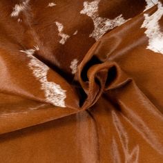 an animal print fabric with white spots on brown and white furnishing, closeup