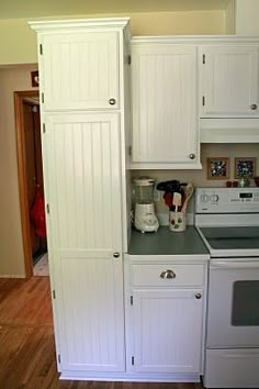 a kitchen with white cabinets and gray counter tops