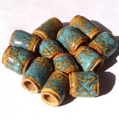 small blue and gold ceramic beads on a white surface