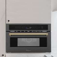 an oven built into the side of a wall with gold trim and black door handles