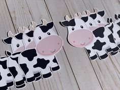 four cow cut outs on a wooden surface