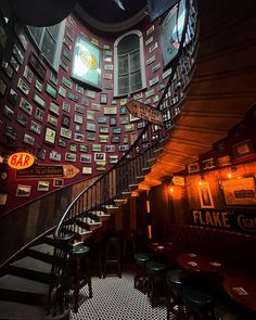 a spiral staircase in a restaurant with lots of signs on the wall