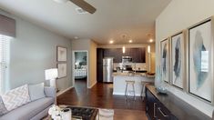 a living room filled with furniture next to a kitchen