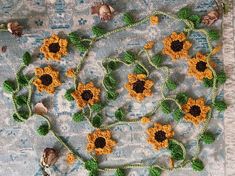 crocheted sunflowers are arranged in the shape of a heart on a tablecloth