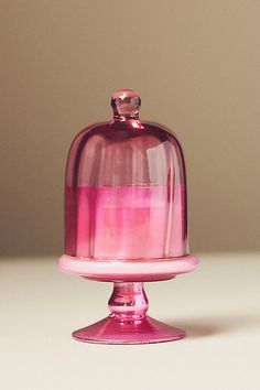 a pink cake stand with a glass dome on top