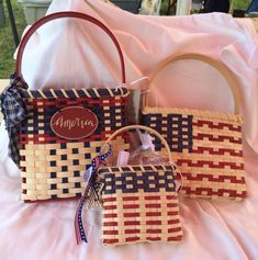 two woven purses sitting on top of a bed