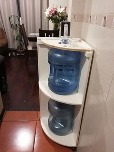 a white shelf with blue water bottles on it