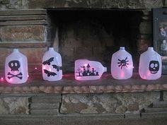 lighted bottles with skulls and bats on them sitting in front of a stone fire place