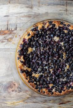 a blueberry pie sitting on top of a glass plate