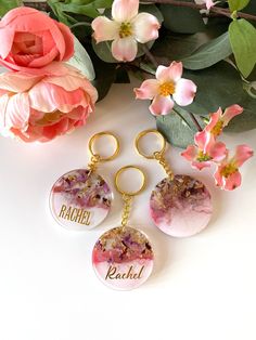 three personalized key chains with flowers in the background